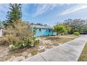 Light blue house with a walkway, and mature landscaping at 1841 Overbrook Ave, Clearwater, FL 33755