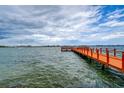 Scenic pier extending over calm waters with a sailboat in the distance at 4575 Cove Cir # 304, St Petersburg, FL 33708