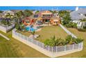 Backyard oasis with pool, patio, lush landscaping, and a white fence at 710 Islebay Dr, Apollo Beach, FL 33572