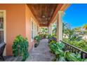 Covered porch with tile flooring, lush greenery, and a relaxing sitting area at 710 Islebay Dr, Apollo Beach, FL 33572