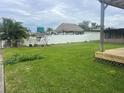 Large grassy backyard with a covered patio and tiki hut at 8540 Riverside, St Petersburg, FL 33702