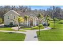 Two-story home with circular driveway and lush landscaping at 11518 Hammock Oaks Ct, Lithia, FL 33547
