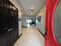 Bright entryway with red door, black double doors, and tile floors at 13828 Tonya Anne Dr, Riverview, FL 33579