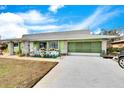 Green ranch home with stone accents, landscaping, and a two-car garage at 1536 W Del Webb Blvd, Sun City Center, FL 33573