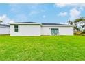 Grass lawn behind a white house with patio furniture at 189 Statler St, Port Charlotte, FL 33954