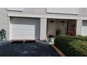 White garage doors and entryway with potted plants at 255 Capri N Cir # 17, Treasure Island, FL 33706