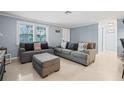 Cozy living room with gray sofas and ottoman, offering a comfortable atmosphere at 3421 Cantrell St, Holiday, FL 34690