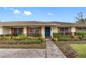 Ranch style home with teal front door and well-maintained landscaping at 3756 E Lake Dr, Land O Lakes, FL 34639