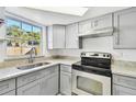 Modern kitchen with gray cabinets, granite countertops, and stainless steel appliances at 4233 Oakfield Ave, Holiday, FL 34691