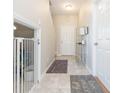 Bright and airy entryway with tile flooring, and access to a downstairs bedroom at 7236 Grand Elm Dr, Riverview, FL 33578