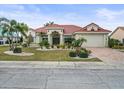 House with a red tile roof, palm trees, and a landscaped lawn at 1209 Peridot Ln, Sun City Center, FL 33573