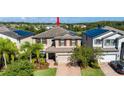 Two-story house with solar panels, brick driveway, and lush landscaping at 19510 Whispering Brook Dr, Tampa, FL 33647