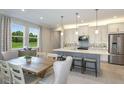Spacious kitchen with white cabinets, gray island, and stainless steel appliances at 20249 Symphony Pl, Venice, FL 34293