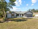 Single story home with gray exterior, arched entryway, and landscaped lawn at 2139 Abby Ave, Spring Hill, FL 34609