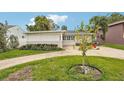 House exterior, featuring a well-manicured lawn and a carport at 3435 Overlook Ne Dr, St Petersburg, FL 33703