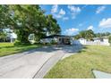 Ranch-style home with carport, mature landscaping, and spacious driveway at 604 Danube Ave, Tampa, FL 33606