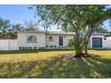 Updated single story home with a large tree and a modern garage at 7516 38Th N Ave, St Petersburg, FL 33710