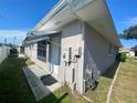 Rear view of a single-story house with a back door at 889 Sky Loch S Dr, Dunedin, FL 34698