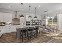 Modern kitchen with white cabinets, gray island, stainless steel appliances, and hardwood floors at 12652 Glenn Creek Dr, Riverview, FL 33569