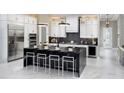 Modern kitchen with a large black island, white cabinets, and stainless steel appliances at 14638 Swiss Bridge Dr, Lithia, FL 33547