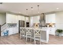Modern white kitchen with island, stainless steel appliances, and white cabinets at 14814 Paddock Pond Ave, Lithia, FL 33547