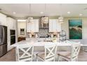 Modern white kitchen with island, stainless steel appliances, and white cabinets at 14814 Paddock Pond Ave, Lithia, FL 33547