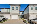 Front view of a townhome with a light gray exterior and white garage door at 1621 Eagle Creek Dr, Clearwater, FL 33764