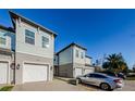 Townhome with light gray siding, white garage doors, and landscaping at 1621 Eagle Creek Dr, Clearwater, FL 33764