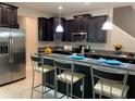 Modern kitchen with dark wood cabinets, granite countertops, and breakfast bar at 17241 Old Tobacco Rd, Lutz, FL 33558