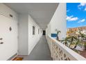 Condo hallway with white walls, gray flooring, and access to unit 208 at 7 Elgin Pl # 208, Dunedin, FL 34698