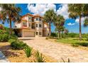 Grand home with a large driveway, palm trees, and beautiful landscaping at 8731 Betty St, Port Richey, FL 34668