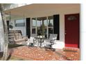 Relaxing front porch with tile flooring, wooden swing, and seating for two at 9705 45Th N Way, Pinellas Park, FL 33782