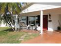Front porch with red door, wooden swing, and seating area at 9705 45Th N Way, Pinellas Park, FL 33782