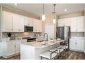 Modern kitchen with white cabinets, stainless steel appliances, and an island at 10237 Fieldstone Myrtle Way, San Antonio, FL 33576