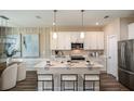 Modern kitchen with white cabinets, stainless steel appliances, and an island at 10237 Fieldstone Myrtle Way, San Antonio, FL 33576