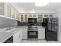 White kitchen with stainless steel appliances and breakfast bar at 105 Island Way # 146, Clearwater, FL 33767