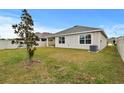 Large backyard with grassy lawn, and a covered patio at 17019 Avon Dive Ln, Wimauma, FL 33598