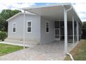 Gray mobile home with covered carport and screened porch at 3722 Spinnaker Dr, Tampa, FL 33611