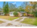 Brick home with a yellow door and a well-maintained lawn at 505 Jefferson S Ave, Oldsmar, FL 34677