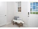 Bright entryway with a bench, pillows, and a view of the backyard at 12094 New Tranquility Path, Venice, FL 34293