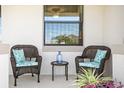 Relaxing front porch with wicker chairs, side table, and potted plants at 13614 Tonya Anne Dr, Riverview, FL 33579