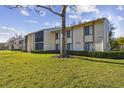 Condo building with a tree and well-maintained landscaping at 1433 Pine Glen Pl # D1, Tarpon Springs, FL 34688