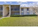 Two-story condo building with screened balconies and landscaping at 1433 Pine Glen Pl # D1, Tarpon Springs, FL 34688