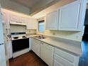 Kitchen with white cabinets, laminate flooring, and appliances at 1568 Nantucket Ct # 1302, Palm Harbor, FL 34683