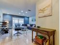 Home office features glass desk, comfortable seating, and a view of the backyard at 16115 Country Crossing Dr, Tampa, FL 33624