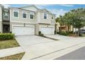 Two-story townhome with attached two-car garage and lush landscaping at 1815 Sunset Wind Loop # 118, Oldsmar, FL 34677