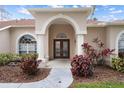 Elegant front entry with arched doorway, columns, and landscaping at 2342 Edelweiss Loop, Trinity, FL 34655