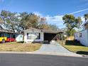 Single-wide manufactured home with carport and landscaped yard at 34421 Countryside Dr, Wesley Chapel, FL 33543