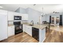 Modern kitchen with granite countertops, white cabinets, and black appliances at 5301 Watson Rd, Riverview, FL 33578