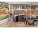 Outdoor kitchen with sink, cabinets, and dining area under a screened patio at 5301 Watson Rd, Riverview, FL 33578